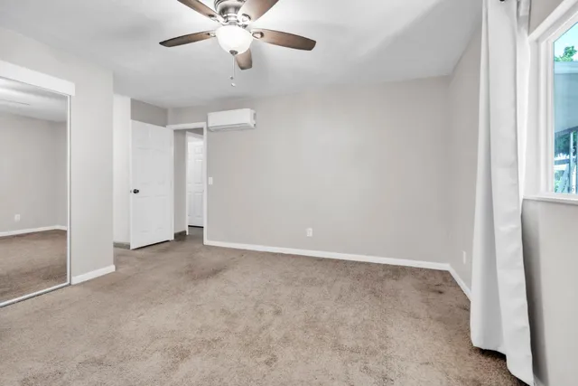 an empty room with a ceiling fan and a window