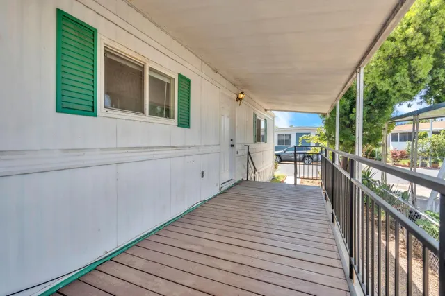 a view of a house with wooden deck and furniture