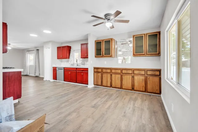 a large white kitchen with stainless steel appliances granite countertop a stove and a wooden floors