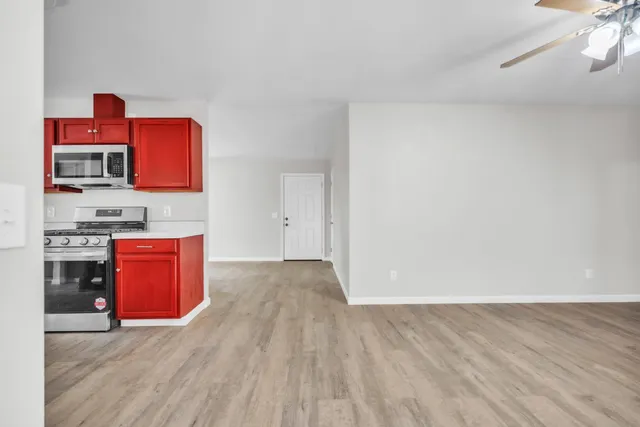a view of an empty room with a window and wooden floor