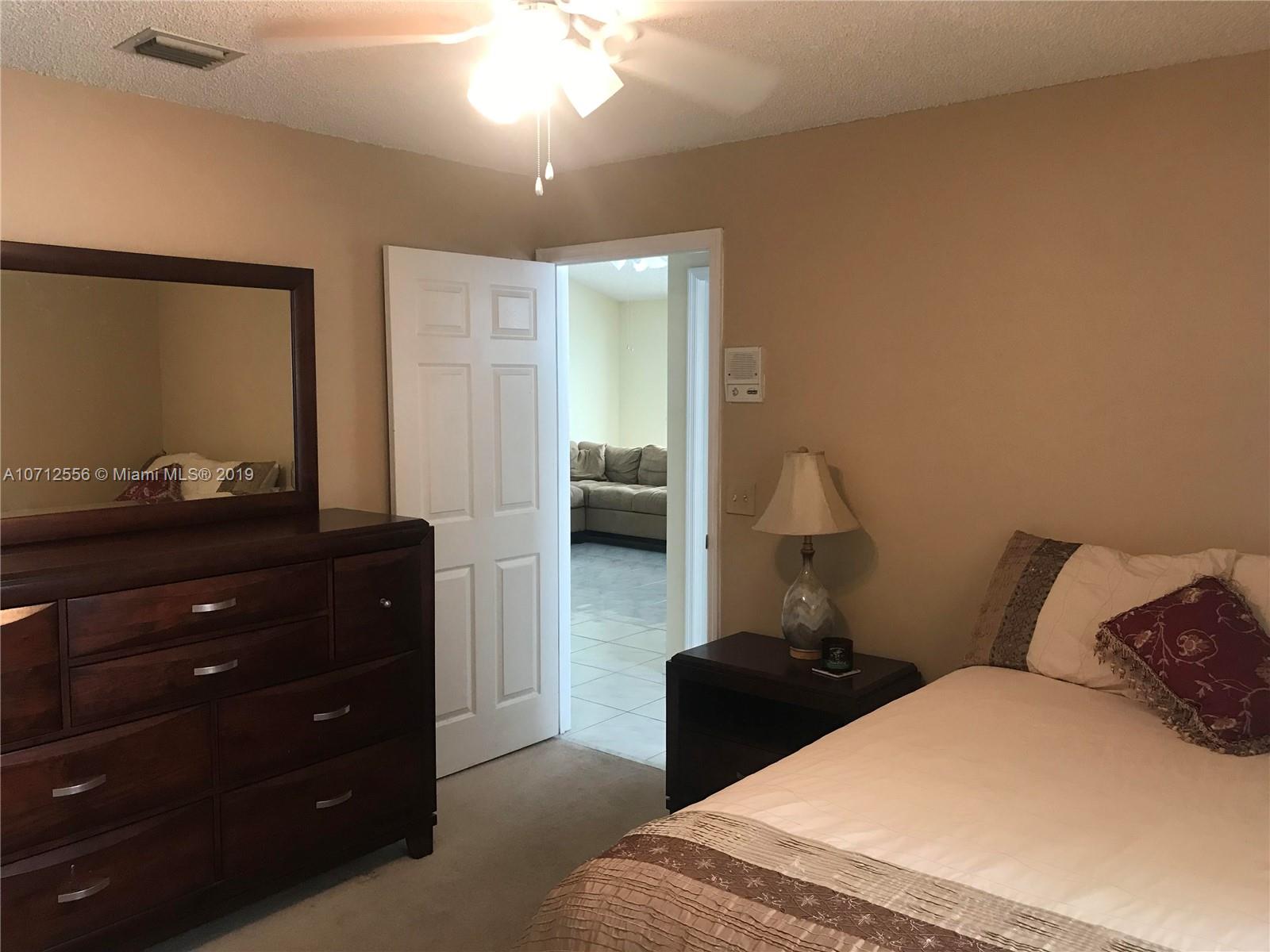 7379 Shell Ridge Terrace Lake Worth, FL 33467 - Photo 13 of 22 a bedroom with a bed and a dresser