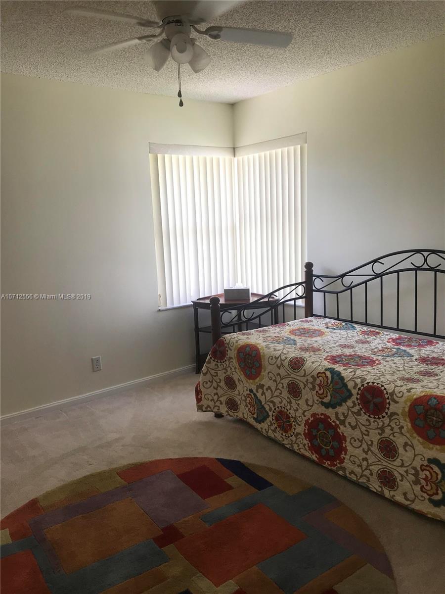 7379 Shell Ridge Terrace Lake Worth, FL 33467 - Photo 14 of 22 a spacious bedroom with a bed next to a window