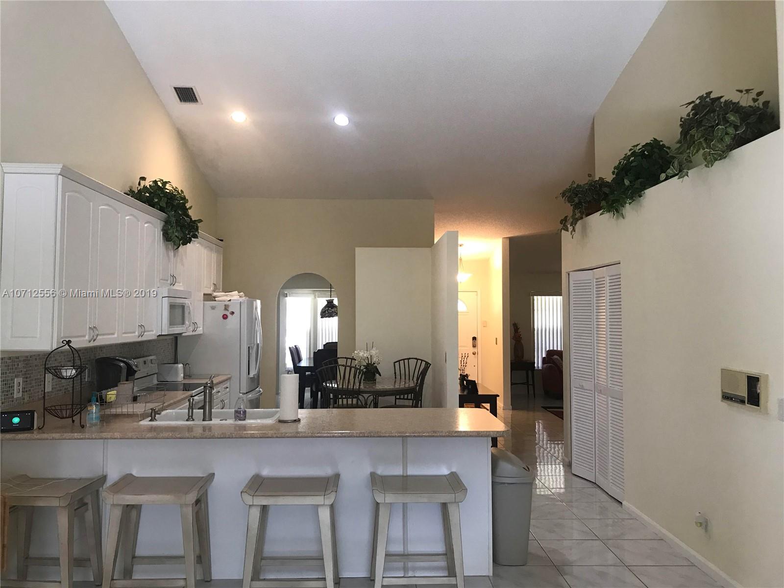 7379 Shell Ridge Terrace Lake Worth, FL 33467 - Photo 8 of 22 a kitchen with a sink and chairs