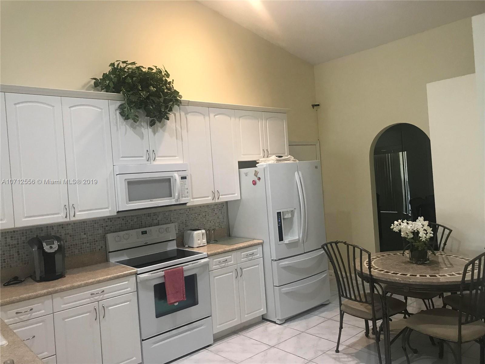 7379 Shell Ridge Terrace Lake Worth, FL 33467 - Photo 9 of 22 a kitchen with stainless steel appliances a refrigerator a stove a sink and chairs
