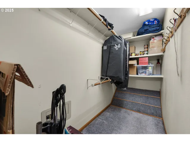 a view of walk in closet with clothes and shoes
