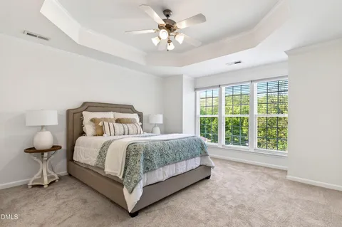 a spacious bedroom with a bed and a chandelier