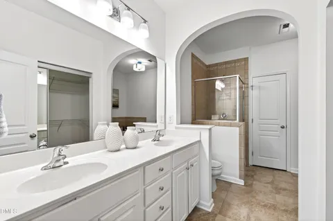 a bathroom with double vanity sinks and a mirror