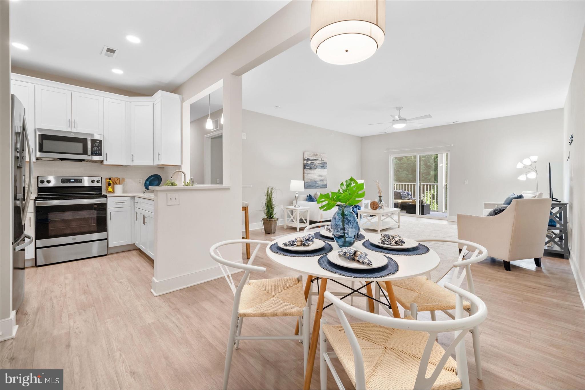 30609 Cedar Neck Road, Unit 3205 Ocean View, DE 19970 - Photo 1 of 28 a kitchen with stainless steel appliances kitchen island granite countertop a kitchen island hardwood floor and a sink