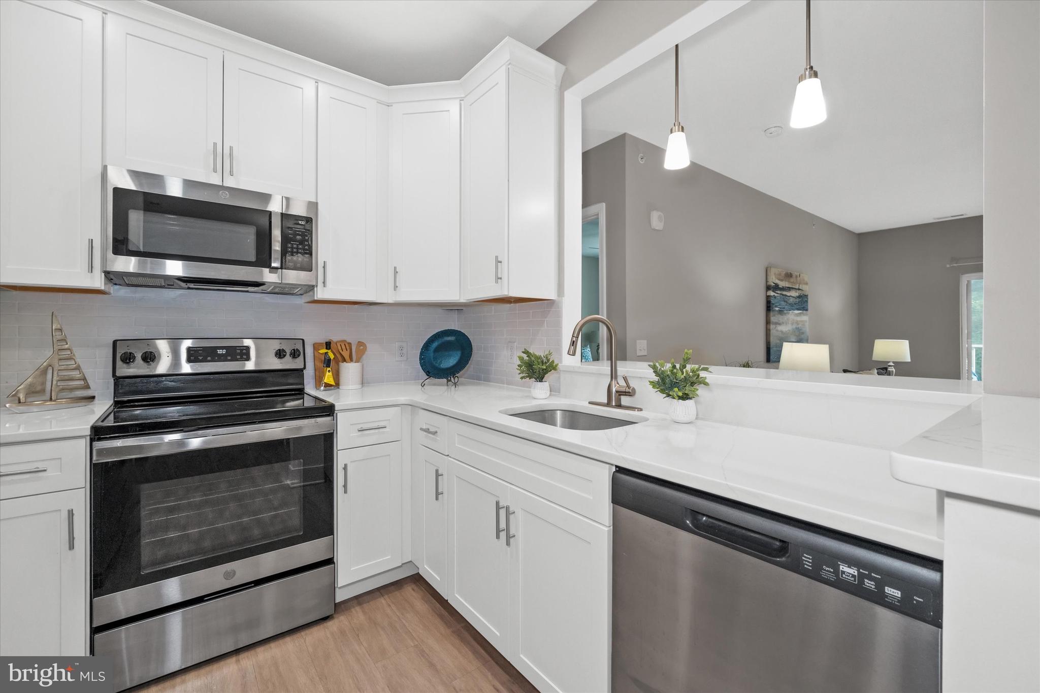 30609 Cedar Neck Road, Unit 3205 Ocean View, DE 19970 - Photo 7 of 28 a kitchen with stainless steel appliances white cabinets and a sink