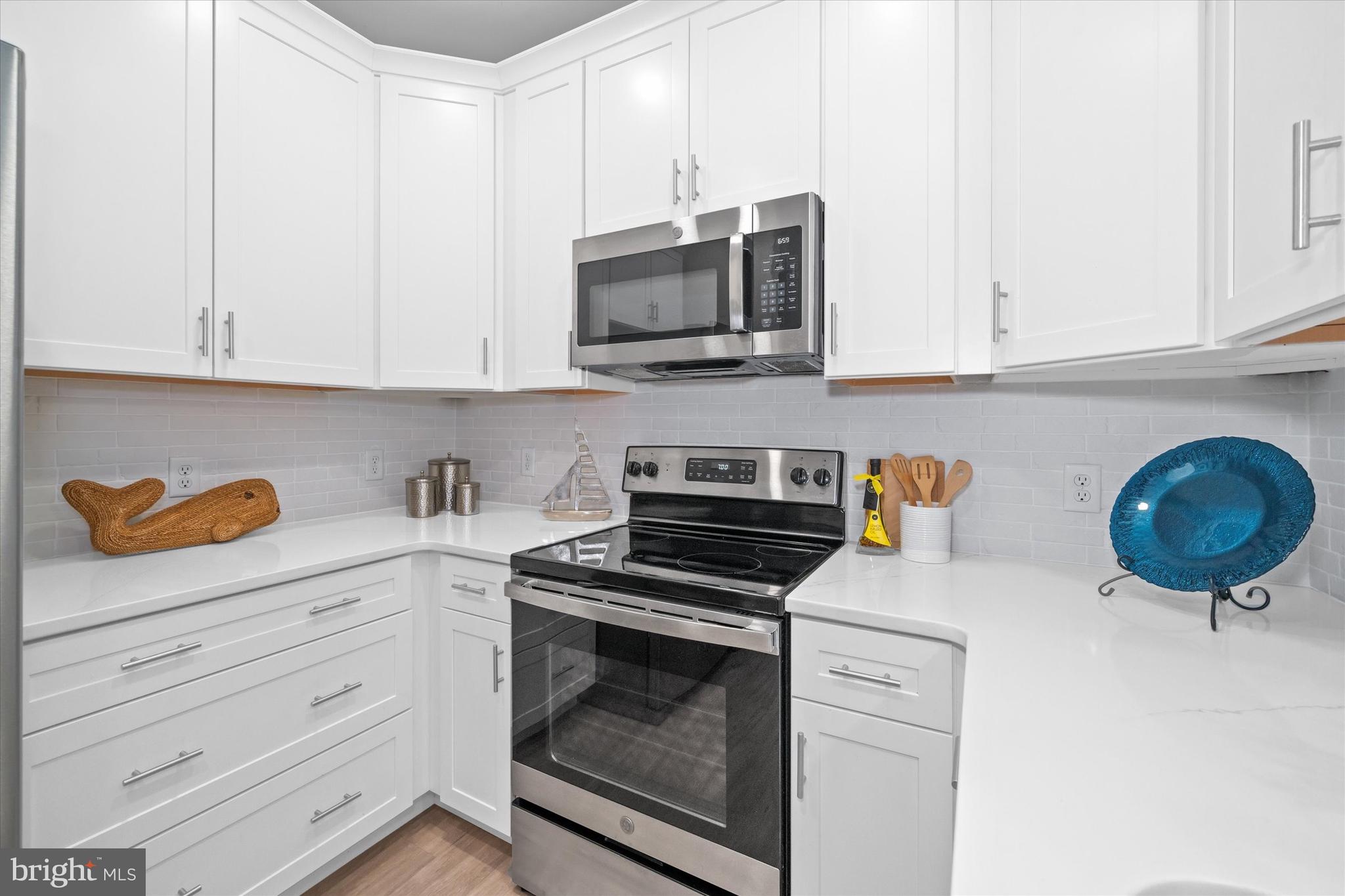 30609 Cedar Neck Road, Unit 3205 Ocean View, DE 19970 - Photo 10 of 28 a kitchen with stainless steel appliances granite countertop a stove a microwave and cabinets