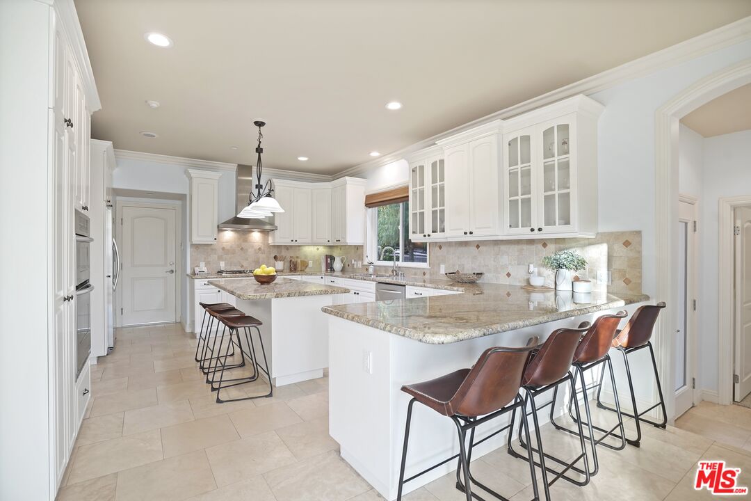 969 Crown Hill Drive Simi Valley, CA 93063 - Photo 15 of 62 a kitchen with kitchen island granite countertop a sink and cabinets