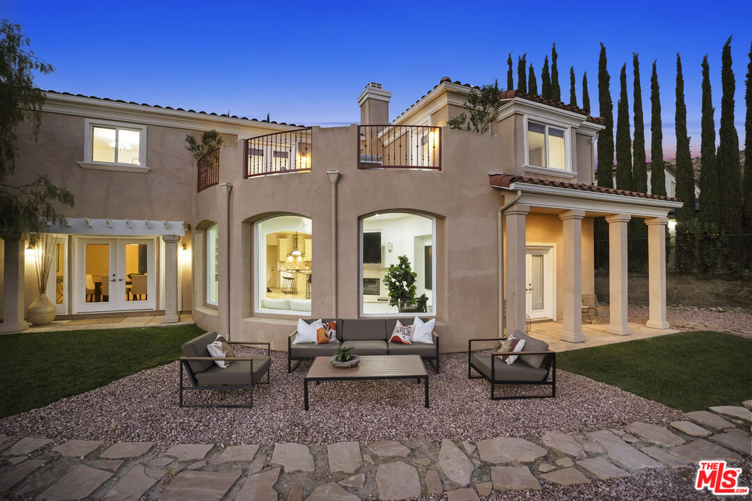 969 Crown Hill Drive Simi Valley, CA 93063 - Photo 50 of 62 a view of a brick house with large windows and a table in a patio