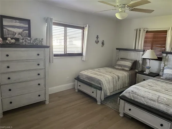 a bedroom with two beds and painting on the wall
