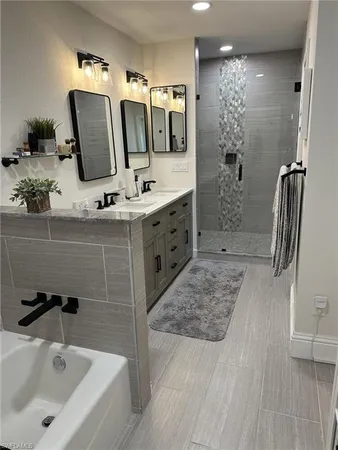a bathroom with a tub sink and mirror