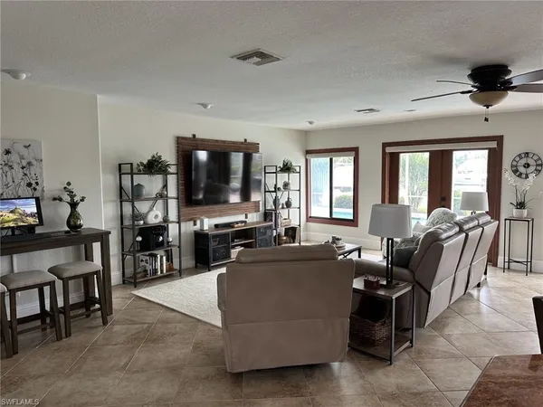 a living room with furniture a flat screen tv and a large window