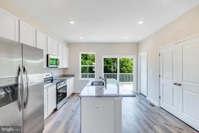 a kitchen with stainless steel appliances granite countertop a sink and stove