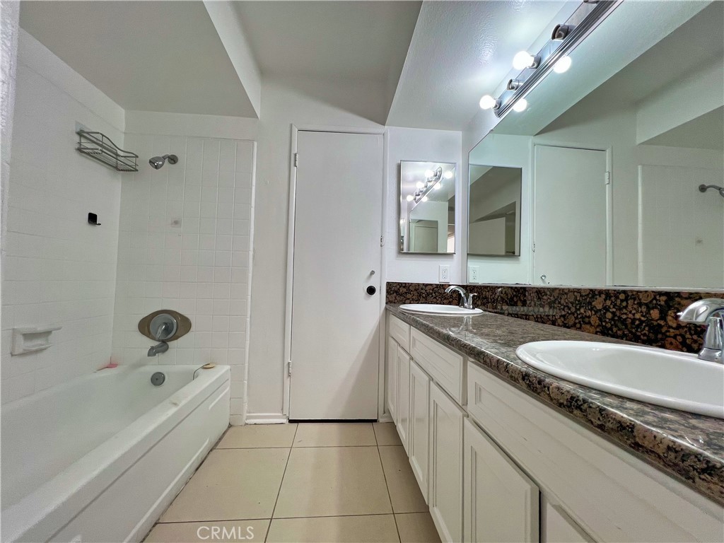 22574 Kentfield Street Grand Terrace, CA 92313 - Photo 14 of 22 a bathroom with a bathtub a double vanity sink and a mirror