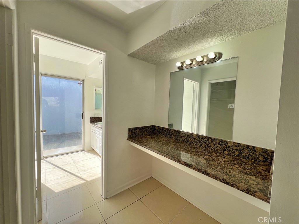 22574 Kentfield Street Grand Terrace, CA 92313 - Photo 16 of 22 a bathroom with a granite countertop sink and a mirror
