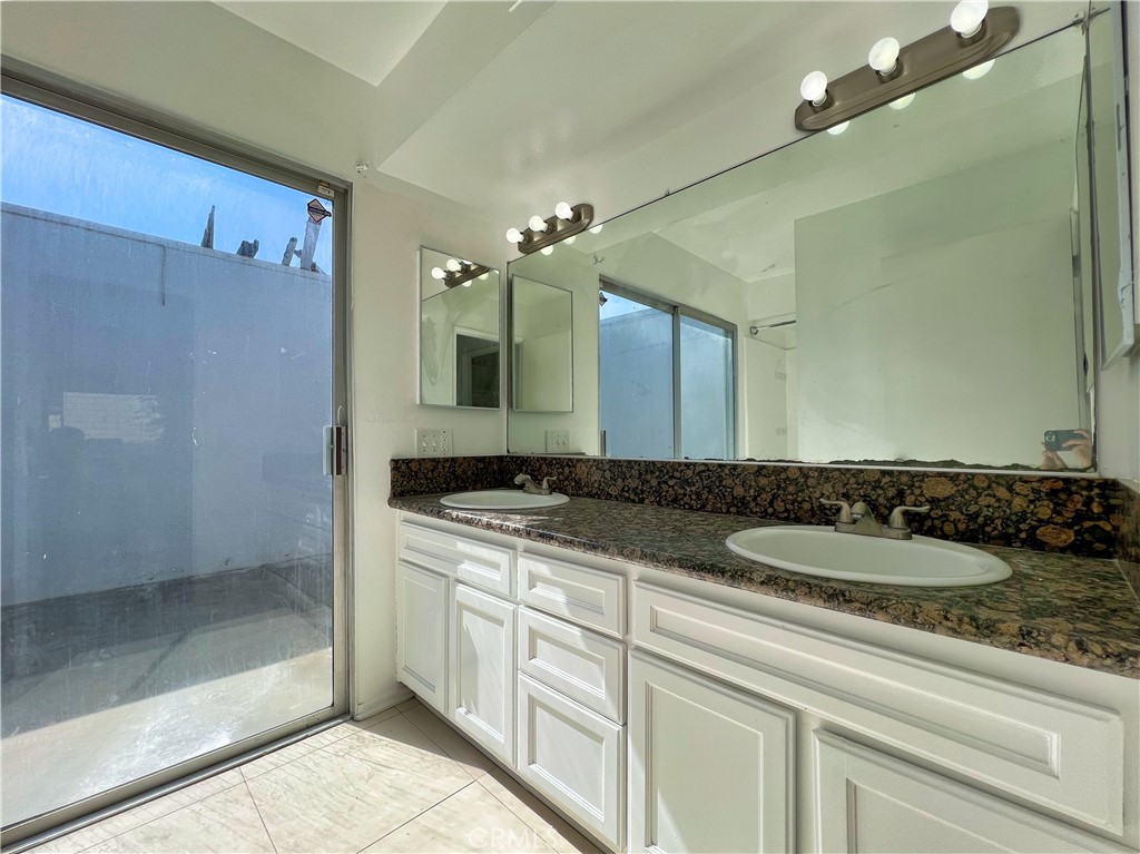 22574 Kentfield Street Grand Terrace, CA 92313 - Photo 22 of 22 a bathroom with a granite countertop sink a mirror and a shower