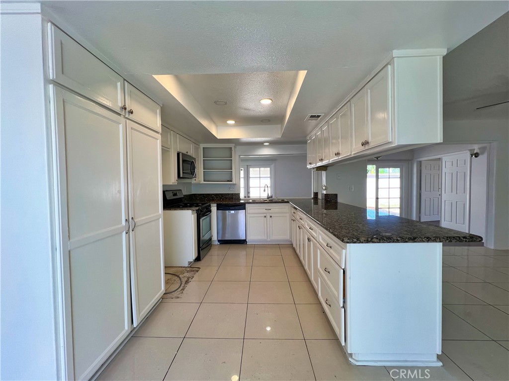 22574 Kentfield Street Grand Terrace, CA 92313 - Photo 6 of 22 a kitchen with stainless steel appliances a sink and a refrigerator