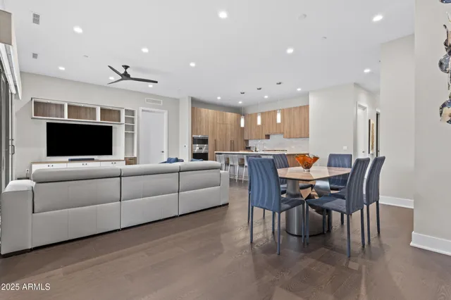 a living room with furniture kitchen and a flat screen tv