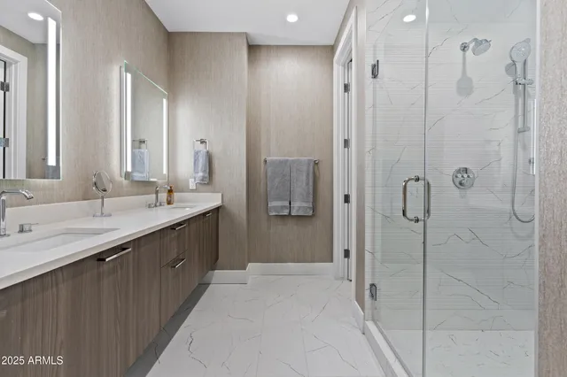 a bathroom with a double vanity sink mirror and shower