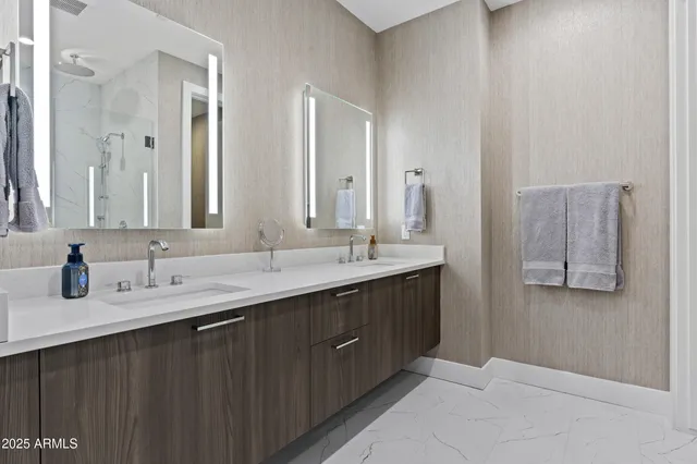 a bathroom with double sink and a mirror