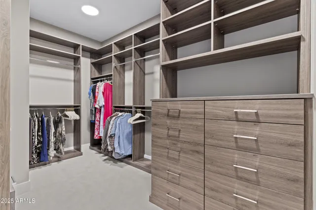 a view of walk in closet with clothes