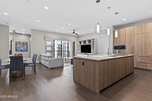 a large kitchen with stainless steel appliances kitchen island granite countertop a large counter top and chairs