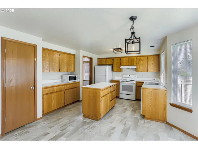 a kitchen with a stove a refrigerator and a sink