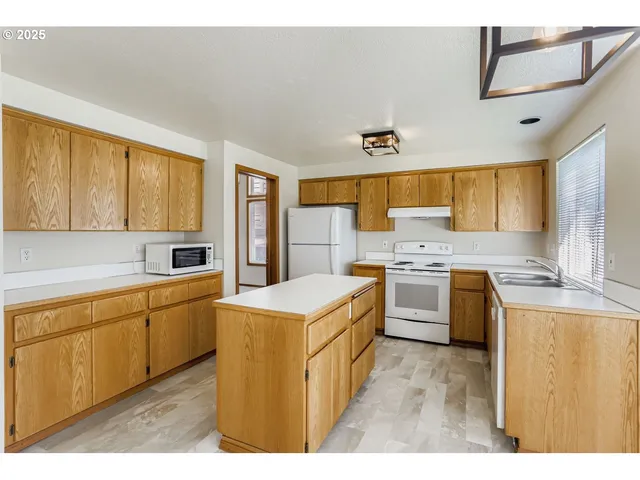 a kitchen with a sink a stove and a microwave
