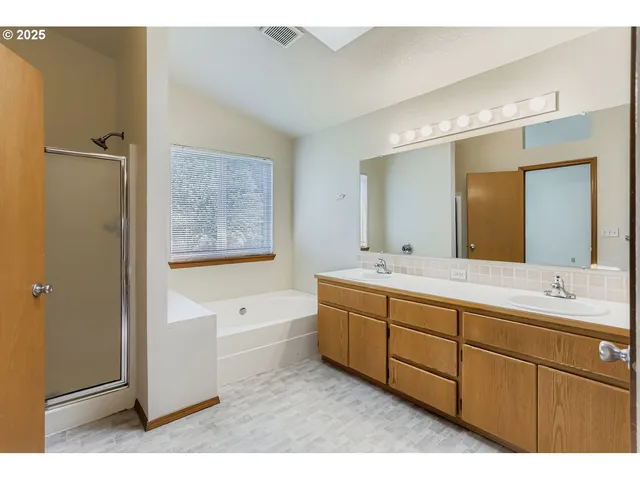 an empty room with windows and chandelier fan
