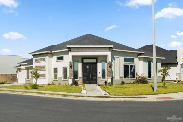 a view of a white house with a swimming pool and a yard