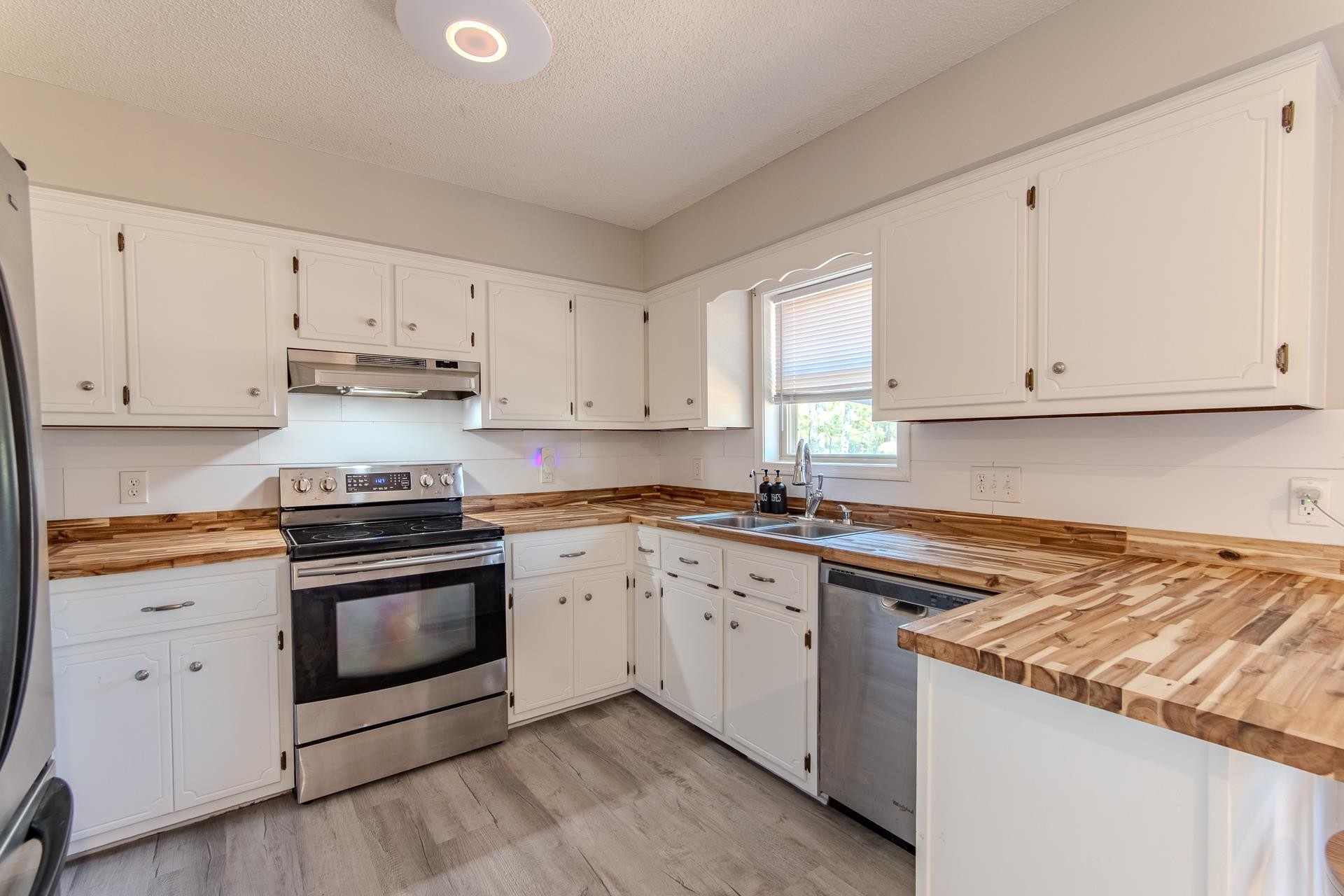 606 Duren Drive Adamsville, TN 38310 - Photo 14 of 40 a kitchen with granite countertop white cabinets and white appliances