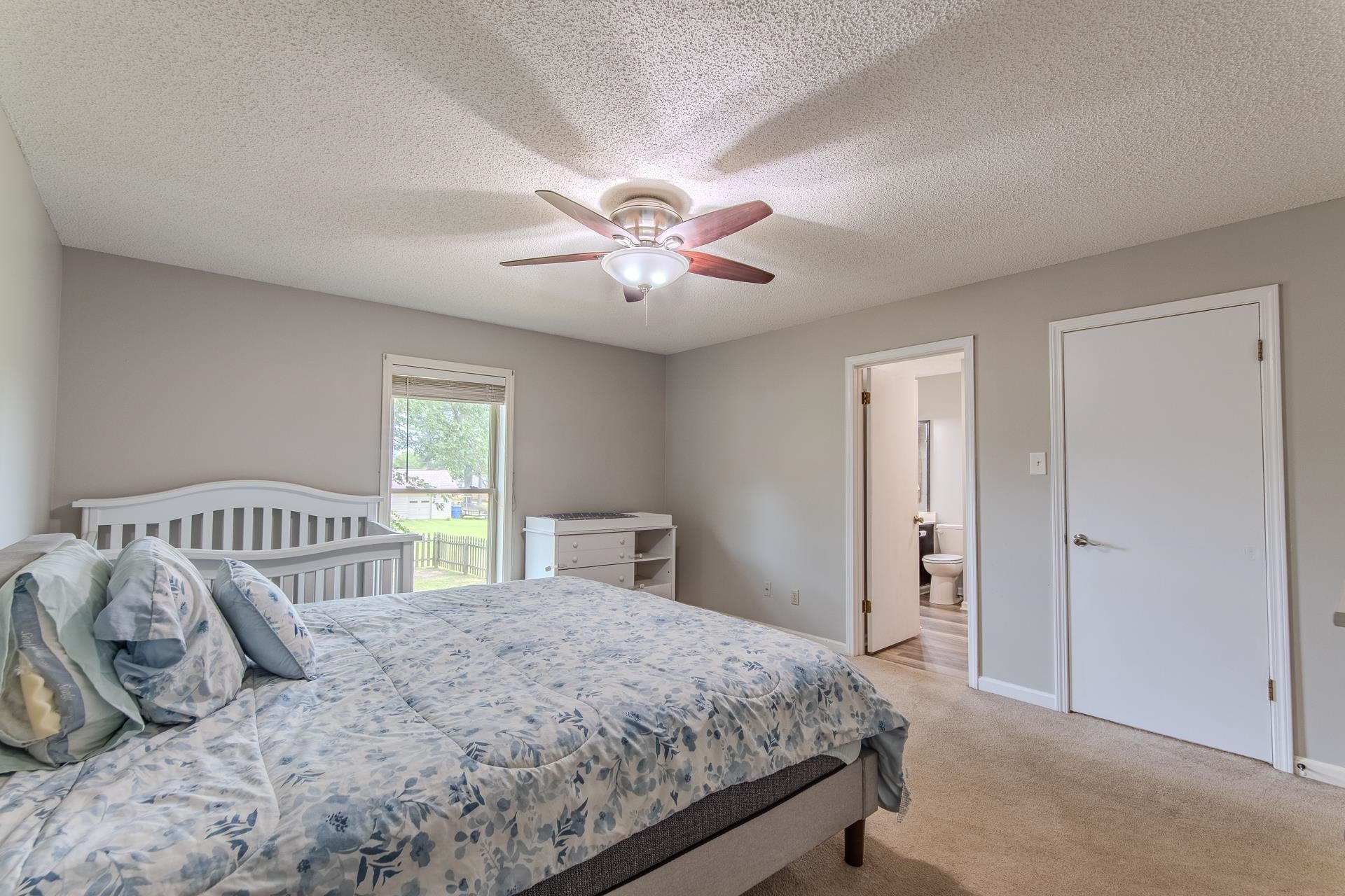 606 Duren Drive Adamsville, TN 38310 - Photo 27 of 40 a bedroom with a large bed and a chandelier