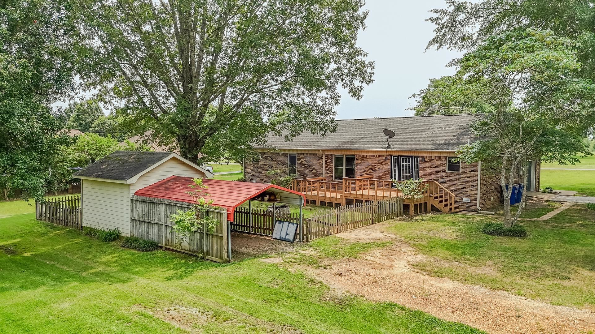 606 Duren Drive Adamsville, TN 38310 - Photo 6 of 40 a view of a house with backyard and a tree