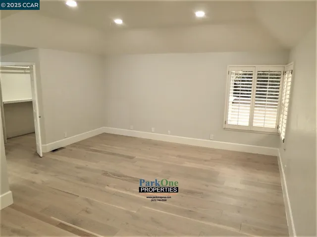 an empty room with wooden floor and window