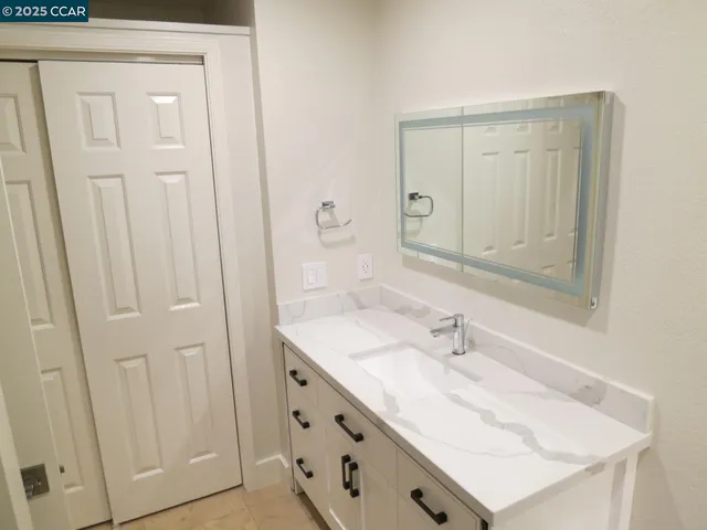 a bathroom with a sink vanity and a mirror
