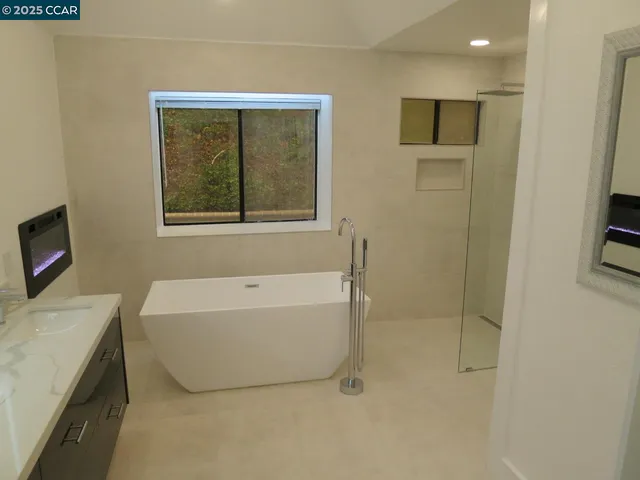 a bathroom with a tub a window and a shower