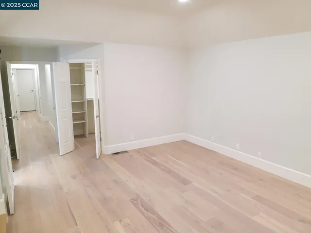 a view of empty room with wooden floor