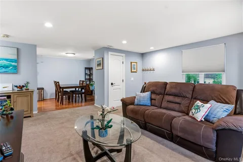 a living room with furniture and a dining table with kitchen view