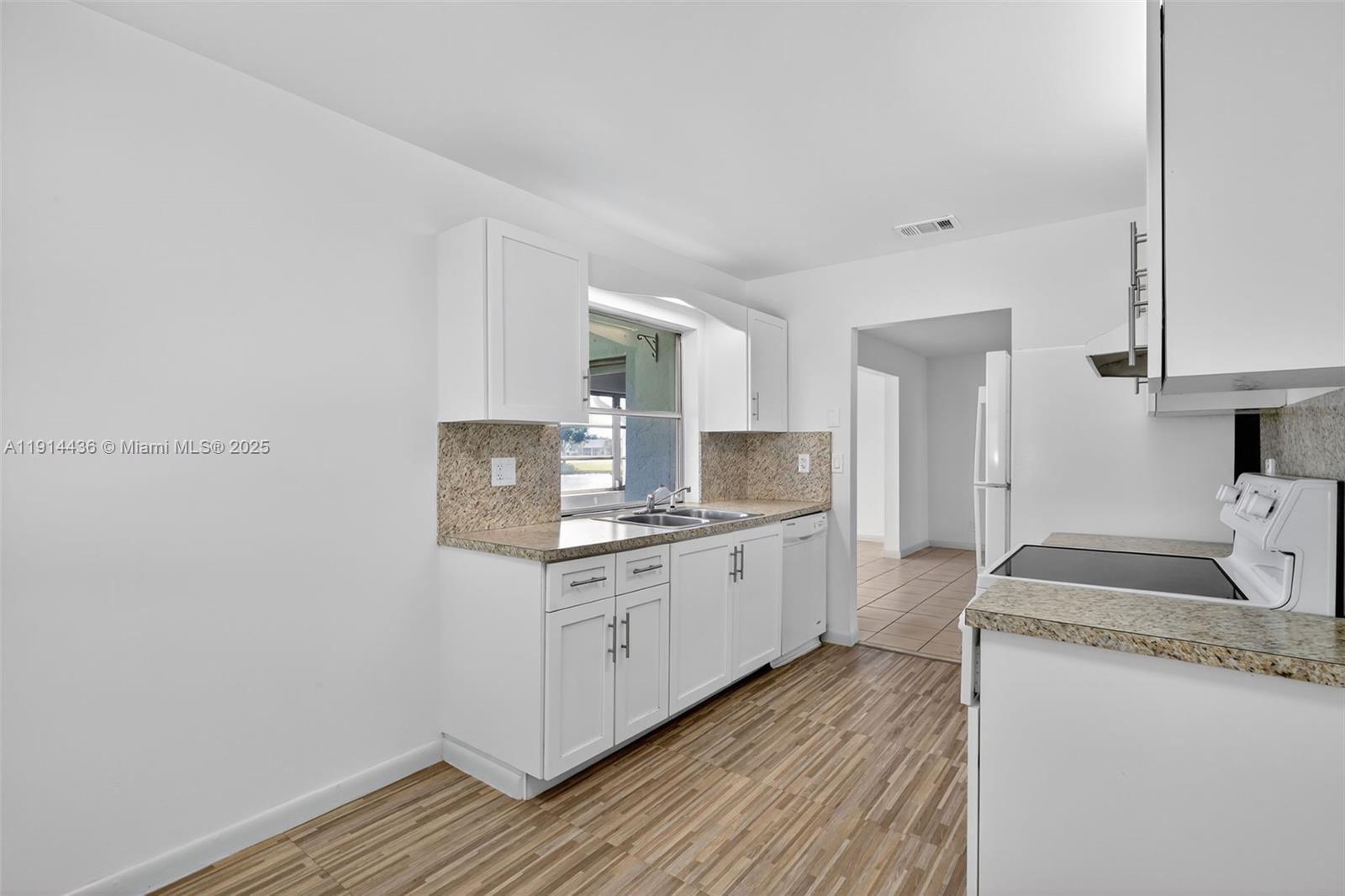 5331 Belleville Road West Palm Beach, FL 33417 - Photo 30 of 49 a kitchen with granite countertop a sink stove and cabinets