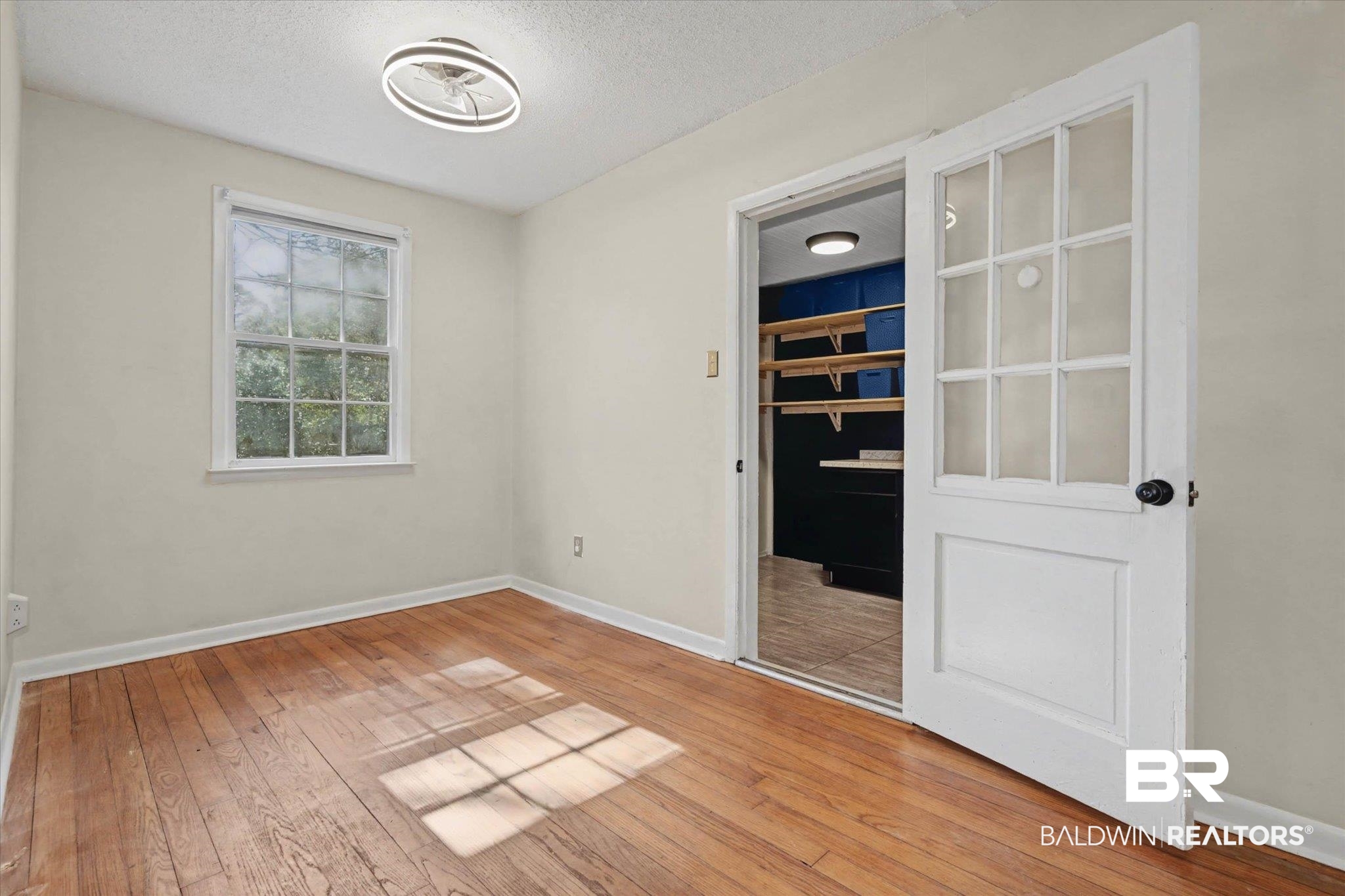 5117 Norton Lane Mobile, AL 36608 - Photo 10 of 35 Unfurnished bedroom with light wood-style floors, a textured ceiling, and a spacious closet