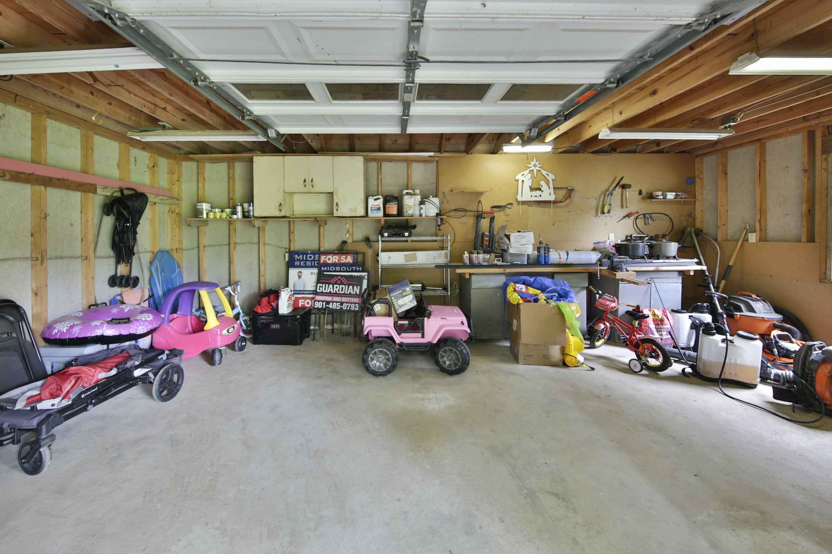 104 Miller Road Covington, TN 38019 - Photo 8 of 25 Spacious garage with exposed wood beam ceiling and concrete flooring