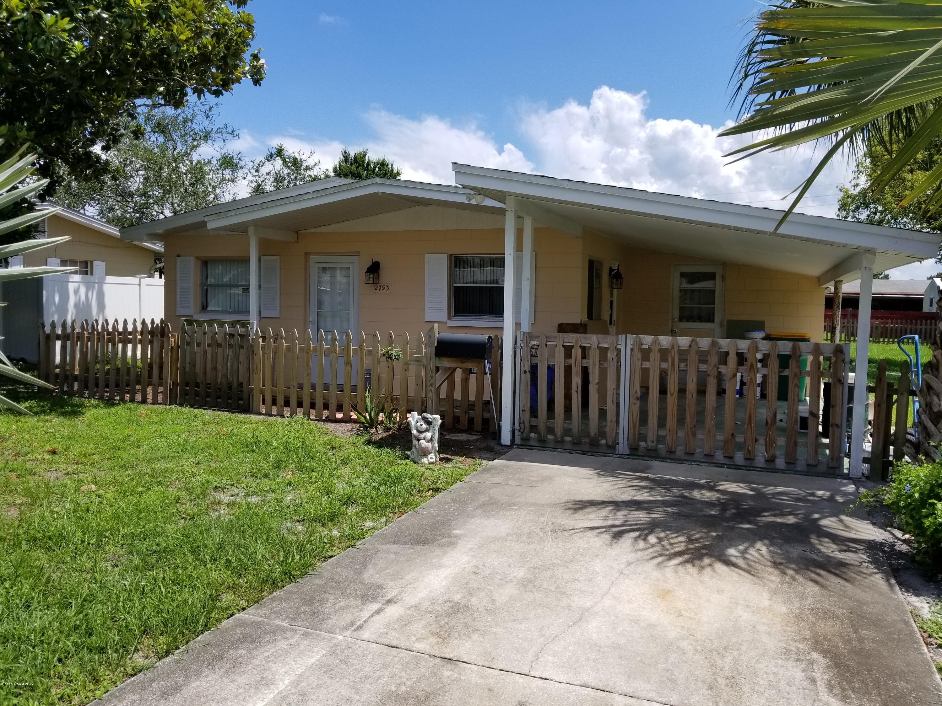 2793 Breeze Ridge Road Melbourne, FL 32935 - Photo 2 of 15 a front view of a house with a garden