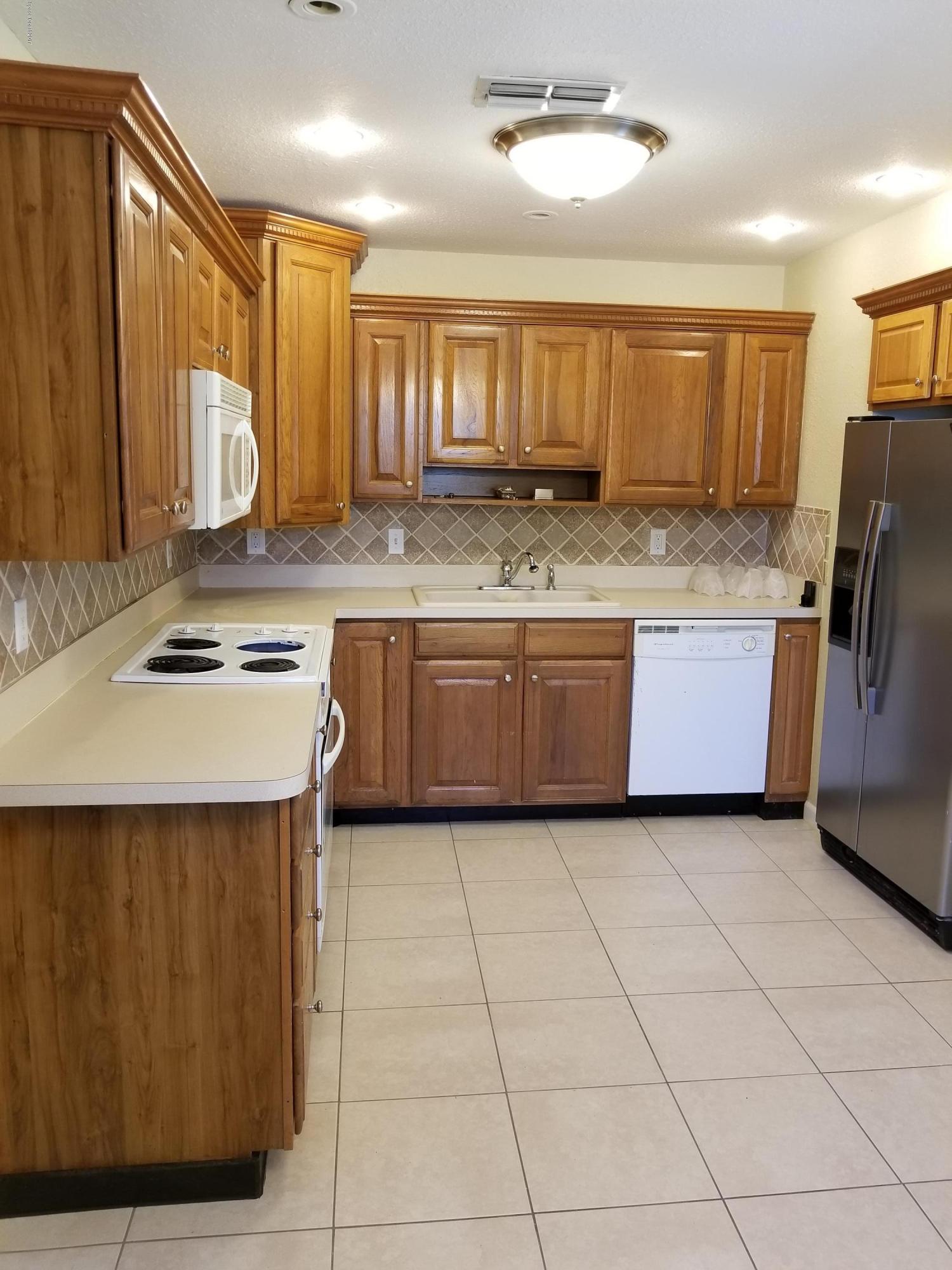 2793 Breeze Ridge Road Melbourne, FL 32935 - Photo 4 of 15 a kitchen with granite countertop a sink and cabinets