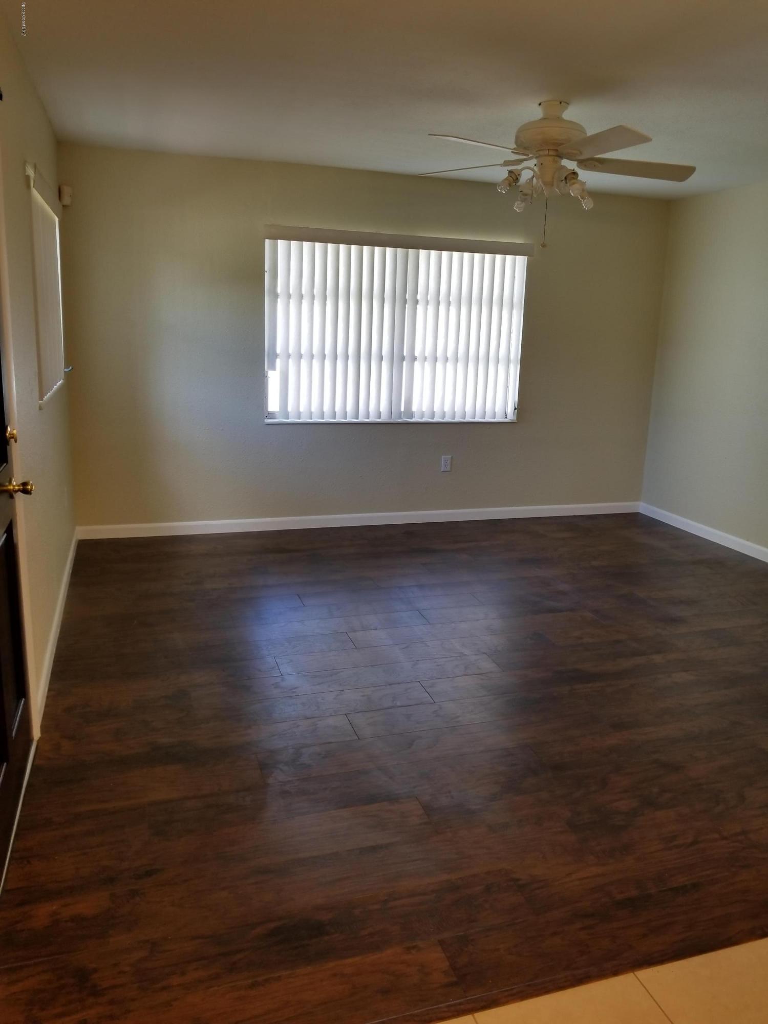 2793 Breeze Ridge Road Melbourne, FL 32935 - Photo 6 of 15 an empty room with wooden floor and windows