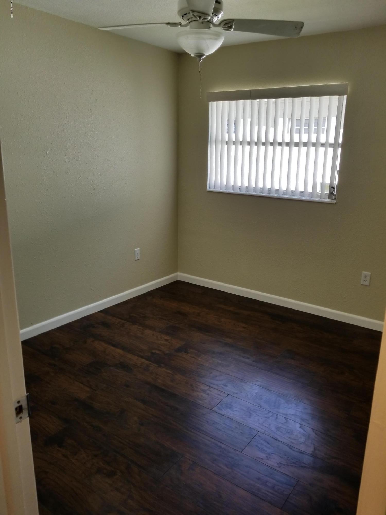 2793 Breeze Ridge Road Melbourne, FL 32935 - Photo 8 of 15 an empty room with wooden floor and windows