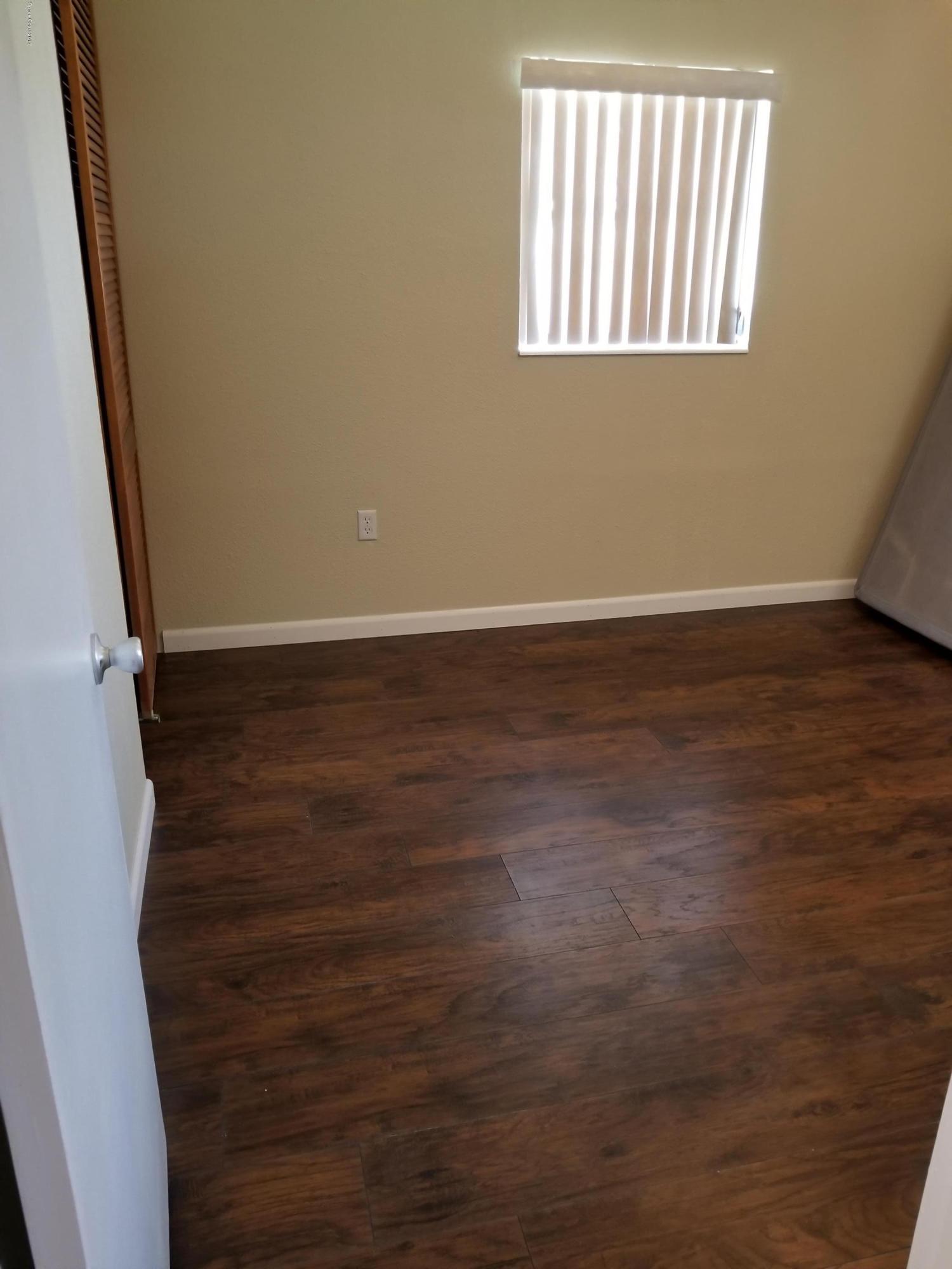 2793 Breeze Ridge Road Melbourne, FL 32935 - Photo 10 of 15 a view of an empty room with wooden floor and a window