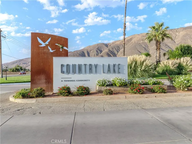 a front view of multi story residential apartment building with yard and parking
